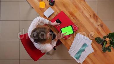 为年轻的高加索女商人在平板电脑<strong>上网</strong>上购物而拍摄的特写镜头，办公室内有<strong>绿色</strong>屏幕